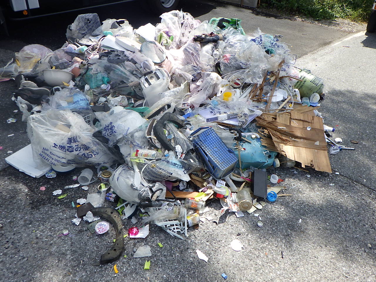 収集車から道路に排出されたごみ。既に消火されている。