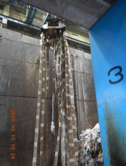 ごみクレーンに垂れ下がるとても長いごみ